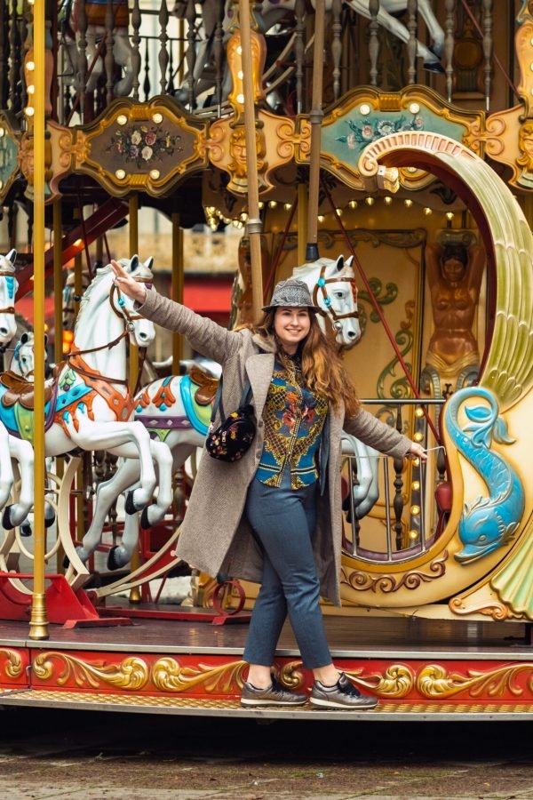 A girl in a coat on the city carousel in Avignon.France.